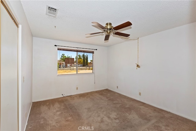 carpeted spare room with ceiling fan and a textured ceiling