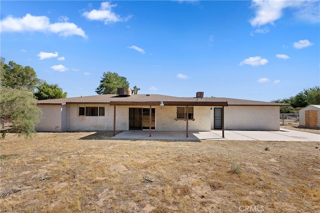 rear view of property featuring a patio, a shed, and central AC unit