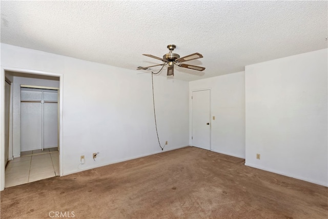 interior space with ceiling fan, carpet floors, a closet, and a textured ceiling