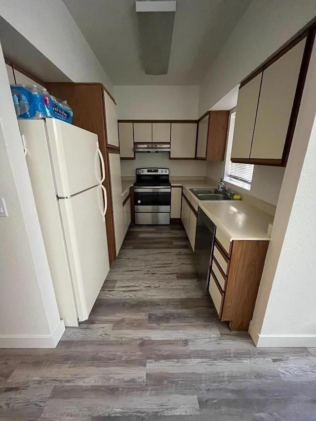 kitchen featuring sink, stainless steel electric range oven, white fridge, and light wood-type flooring