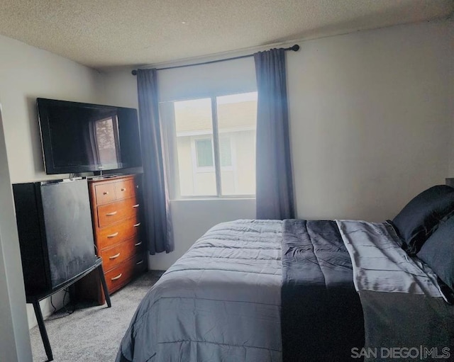 bedroom featuring light colored carpet and a textured ceiling