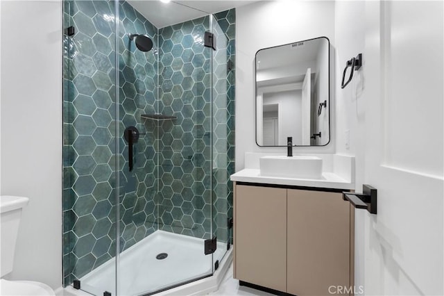 bathroom with vanity, an enclosed shower, and toilet