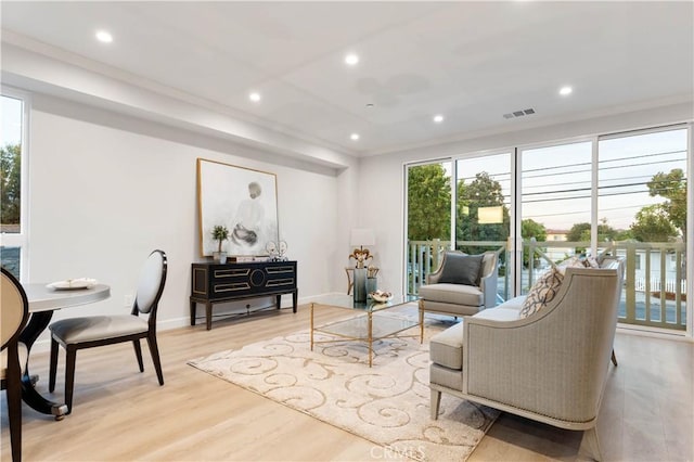 living room with light hardwood / wood-style floors and crown molding