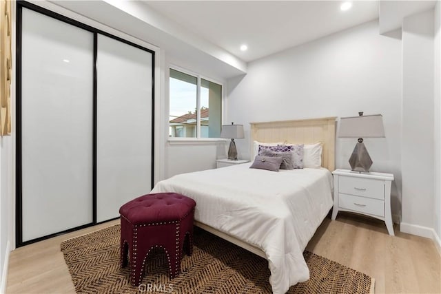 bedroom with light wood-type flooring and a closet