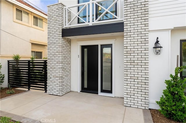 property entrance with a patio area and a balcony