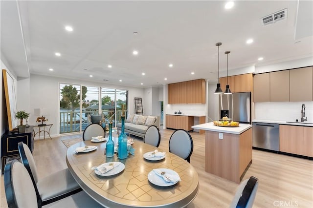 dining space with light hardwood / wood-style floors and sink