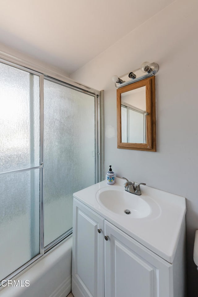 bathroom featuring shower / bath combination with glass door and vanity