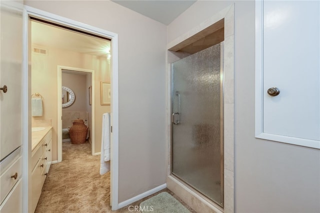 bathroom with a shower with door and vanity