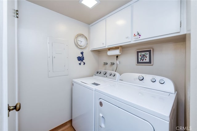 clothes washing area featuring light hardwood / wood-style flooring, electric panel, cabinets, and washer and clothes dryer