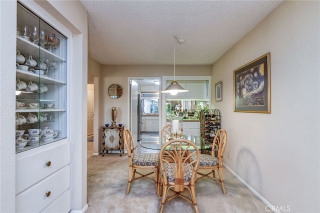 dining space featuring carpet and a textured ceiling