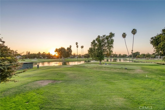 view of home's community with a water view and a yard