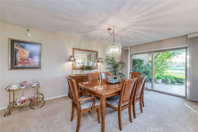 carpeted dining space featuring a notable chandelier and a textured ceiling