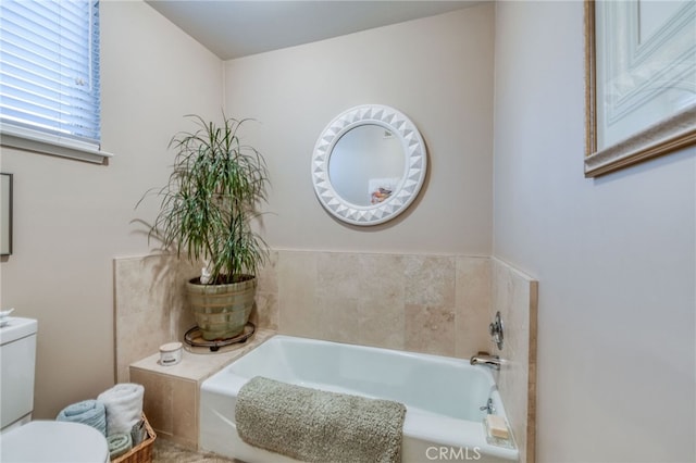 bathroom featuring toilet and a washtub