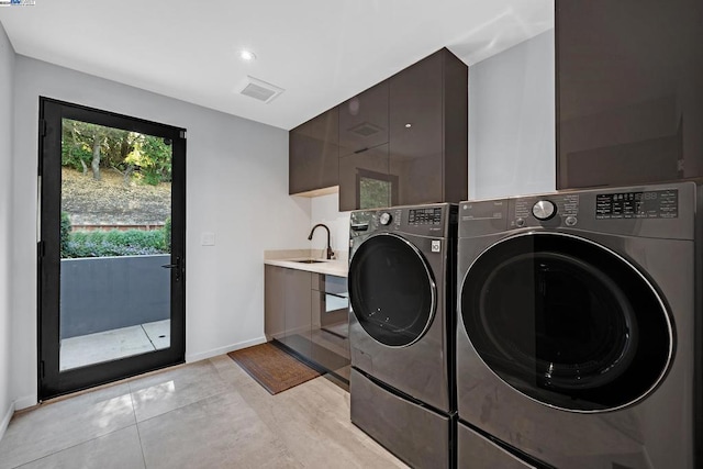 washroom featuring independent washer and dryer, sink, and cabinets