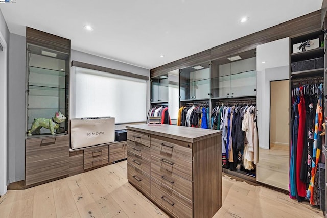 walk in closet with light hardwood / wood-style flooring