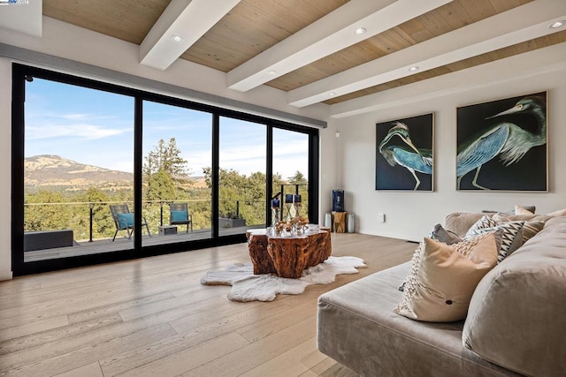 sitting room featuring a mountain view, light hardwood / wood-style flooring, beam ceiling, and wood ceiling