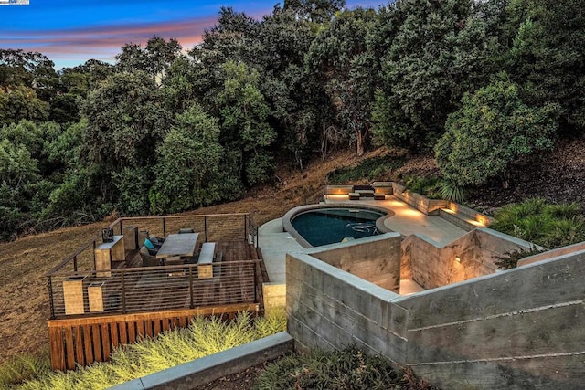 pool at dusk with a jacuzzi