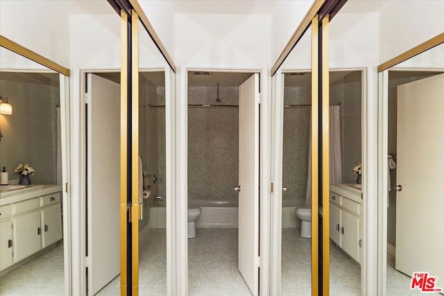 bathroom with a tile shower, vanity, and toilet