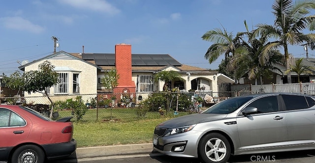 view of front of house with solar panels and a front yard