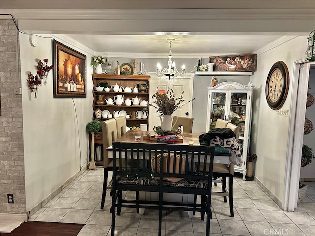 dining space with crown molding, a notable chandelier, and light tile patterned floors