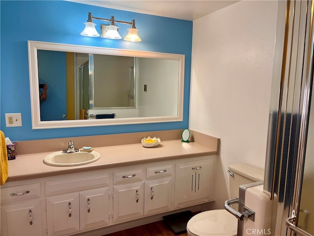 bathroom with vanity, toilet, a shower with door, and hardwood / wood-style flooring