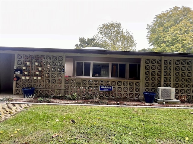 view of side of home with a yard and central AC unit