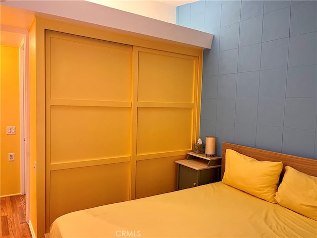 unfurnished bedroom featuring light wood-type flooring and tile walls