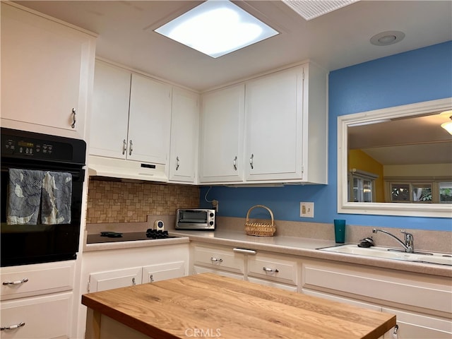 kitchen with wooden counters, tasteful backsplash, lofted ceiling, black appliances, and white cabinetry