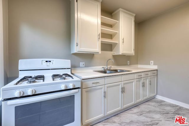 kitchen with white gas range, sink, and white cabinets