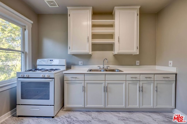 kitchen featuring white cabinets and white gas range