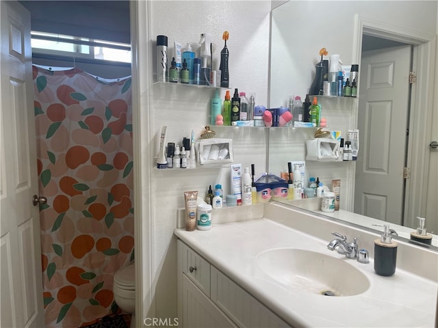 bathroom with vanity, walk in shower, and toilet