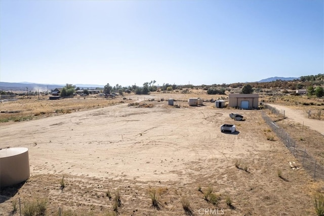 view of yard featuring a mountain view, a rural view, and a storage shed