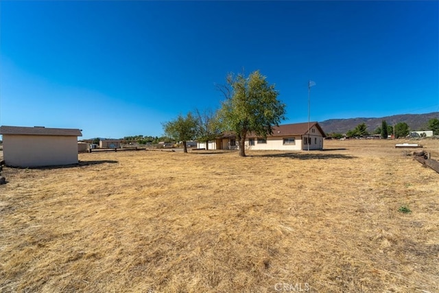 view of yard with a mountain view and a shed