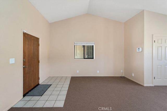 tiled empty room featuring vaulted ceiling