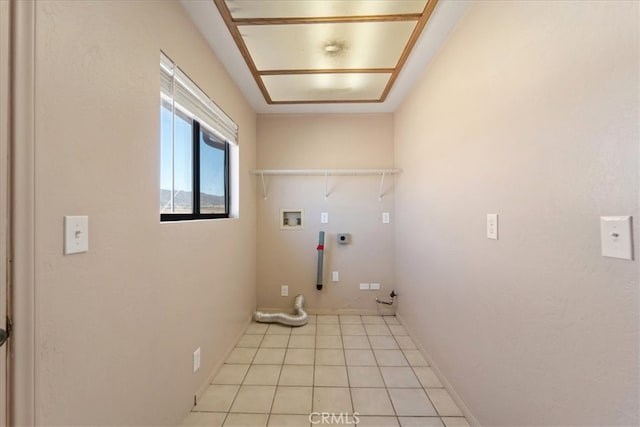 clothes washing area with washer hookup, hookup for a gas dryer, hookup for an electric dryer, and light tile patterned floors