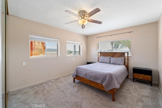 carpeted bedroom with ceiling fan and a textured ceiling