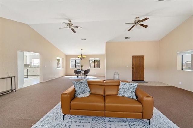 living room featuring ceiling fan with notable chandelier, vaulted ceiling, and light colored carpet