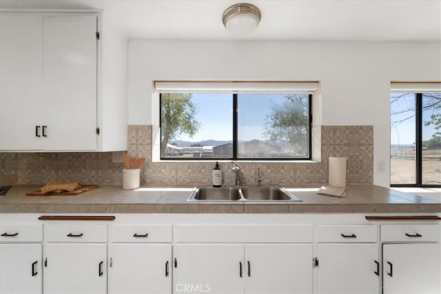 kitchen featuring white cabinets, sink, and a healthy amount of sunlight