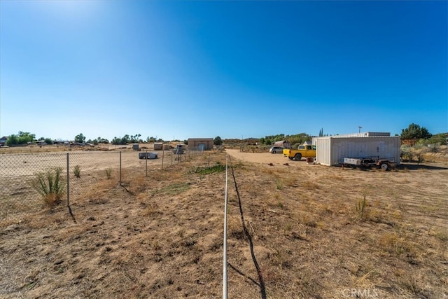 view of yard with a storage unit and a rural view