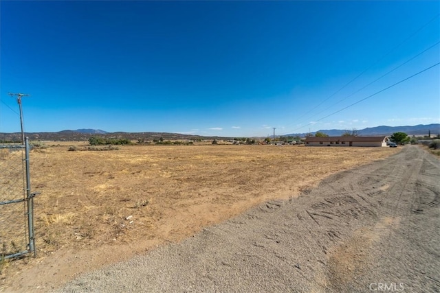 view of yard with a mountain view and a rural view