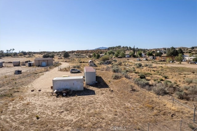 view of yard featuring a rural view and a shed