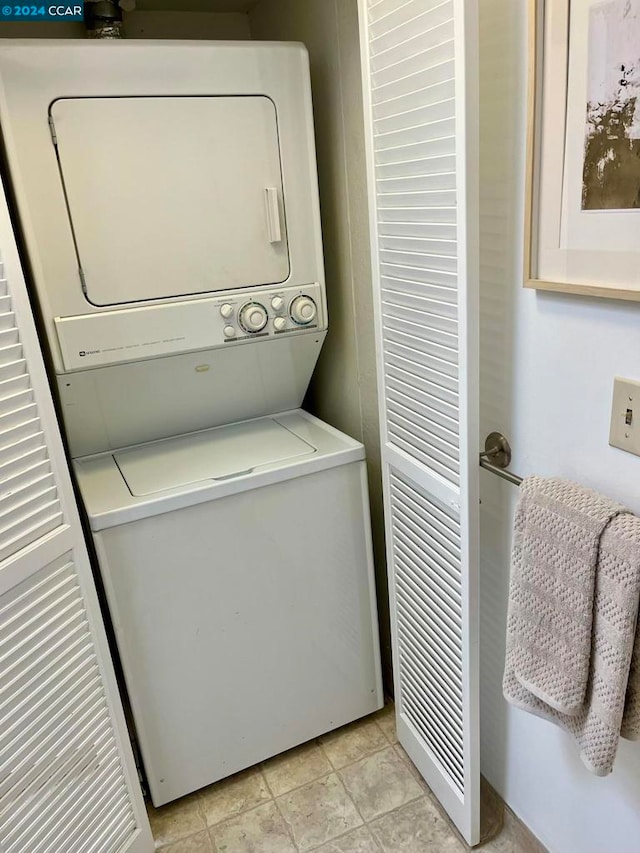 laundry room featuring light tile patterned flooring and stacked washer and clothes dryer