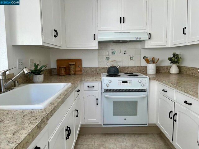 kitchen with white cabinetry, sink, and white range oven