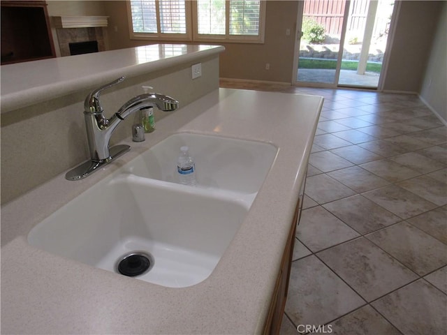 interior details with a tiled fireplace and sink