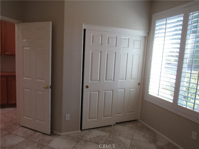 unfurnished bedroom featuring light tile patterned floors and a closet