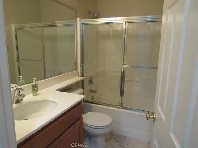 full bathroom with shower / bath combination with glass door, vanity, tile patterned floors, and toilet