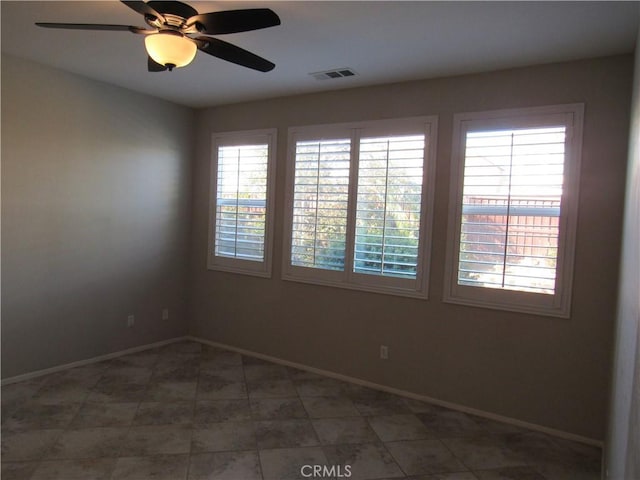 spare room with ceiling fan and a healthy amount of sunlight