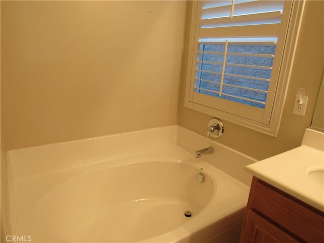 bathroom with vanity and tiled bath