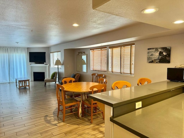 dining room featuring light hardwood / wood-style flooring and a textured ceiling