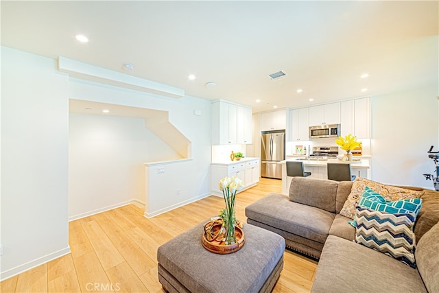 living room with light wood-type flooring and sink